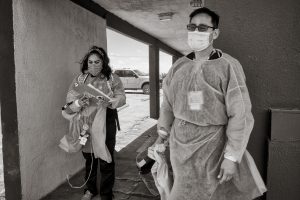 medical providers in masks and gowns walking outside hotel in Gallup NM