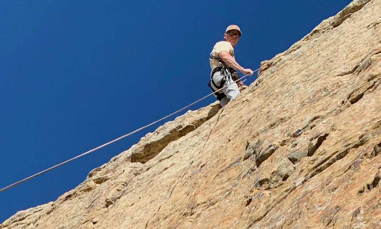Alex Tallant reaches a summit at the Mentmore climbing area in Gallup, NM