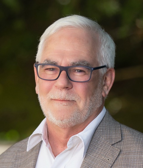 Mike Marcotte's headshot, showing a smiling Anglo man with blue glasses, white hair and a white beard.