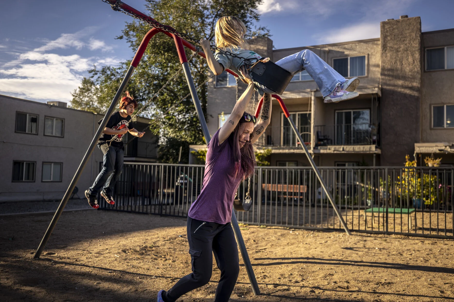 Alyssa Harper, a resident of the Mont 44 apartment complex in Albuquerque, pushes her 7-year-old daughter, Athena Harper, on a swing Monday outside the family’s home, recently flooded with sewage. Harper is one of many tenants of the complex experiencing maintenance issues, spurring a group to form a tenant union. A report, set to be complete later this week, could lead to hundreds of dollars in fines for each violation.
