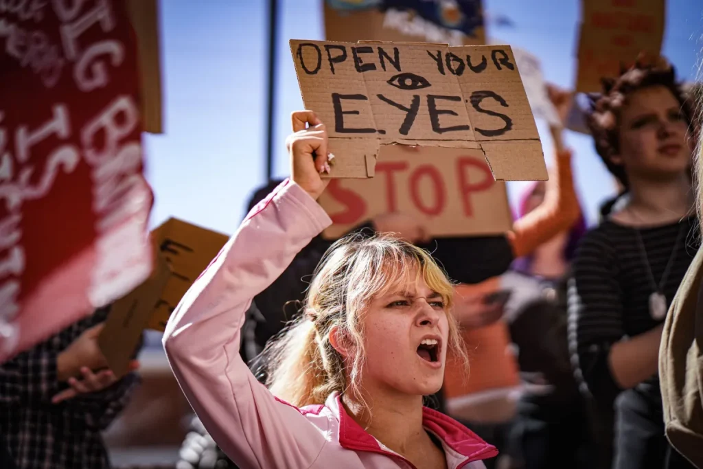 Gre Maestas chants while holding a sign during a protest with students from the New Mexico School for the Arts outside the New Mexico State Capitol following a walkout against Project Jupiter, data centers and artificial intelligence on Tuesday, Oct. 27, 2026.