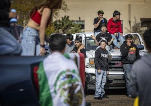 Capital High student J.J. Luévano, left, talks to a few dozen mostly south-side students gathered in the parking lot at the Santa Fe Place mall after a school walkout Wednesday to protest recent immigration raids on construction sites around town.